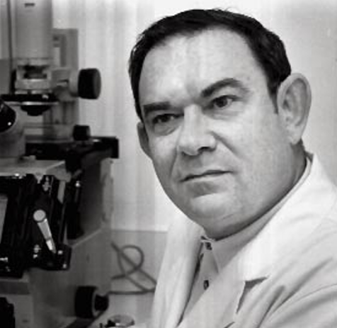 Photo of Leonard Hayflick in front of an inverted microscope